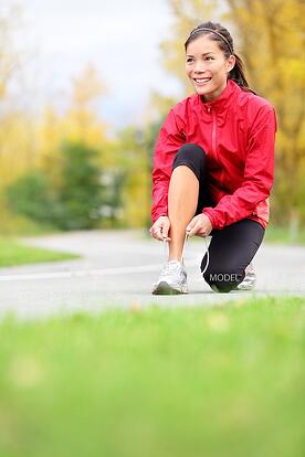 bigstock-Runner-woman-tying-running-sho-36415984